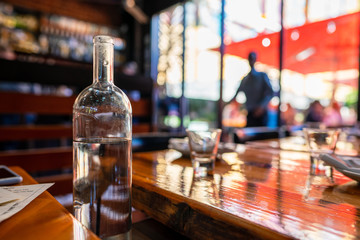 Pitcher of water sitting in shaded moody restaurant in the day