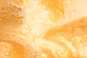 Glittering metallic gold and white coalesce to create this milk and honey abstract background.