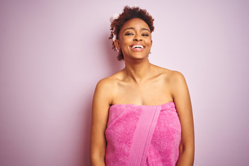 African american woman wearing shower towel after bath over pink isolated background with a happy and cool smile on face. Lucky person.