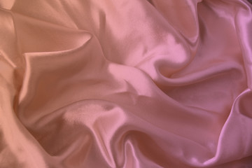 beautiful luxury texture of silk draped fabric with tints of pink, purple, top view, close-up, copy space