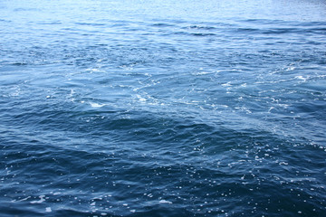 blue sea, ocean waves, water with foam and bubbles, texture, water natural resources concept, close-up, copy space