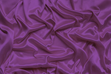 lilac beautiful satin draped with soft folds fabric, silk cloth background, close-up, copy space