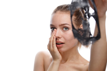 girl takes off cosmetic mask from her face