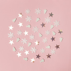Cute winter background. Snow flakes, stars and little christmas trees on pale pink background. Christmas, winter holiday, new year concept.	