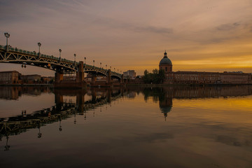 View of Chapelle Saint-Joseph and bridge Pont Saint-Pierre from the square Place Saint-Pierre at Sunset in Toulouse France