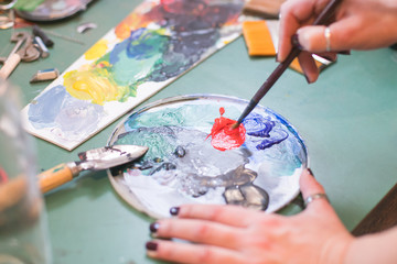 woman artist mixing colors on palette