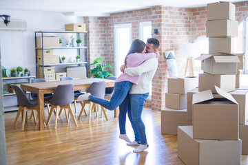 Fototapeta na wymiar Young beautiful couple hugging in love celebrating very happy moving to new apartment