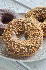 Sweet delicious dessert. Donut with a hole and with chocolate coating and nuts.