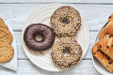 Sweet delicious dessert. Donut with a hole and with chocolate coating and nuts.