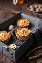 Homemade cinnamon granola cups with raisins and sunflower seeds, filled with toffee, topped with walnut