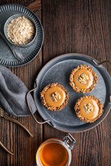 Homemade cinnamon granola cups with raisins and sunflower seeds, filled with toffee, topped with walnut