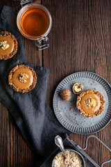 Homemade cinnamon granola cups with raisins and sunflower seeds, filled with toffee, topped with walnut