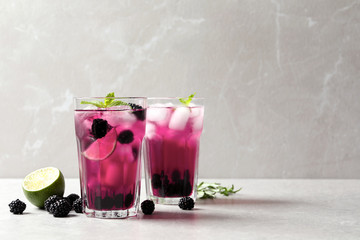 Delicious refreshing blackberry lemonade on light table. Space for text