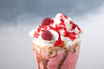 Tasty milk shake with topping on color background, closeup