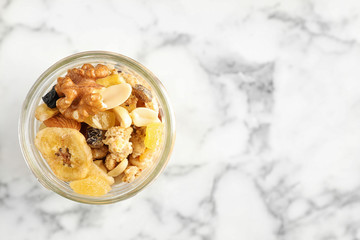 Tasty homemade granola on white marble table, top view with space for text. Healthy breakfast