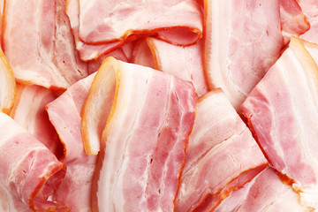 Slices of raw bacon as background, top view