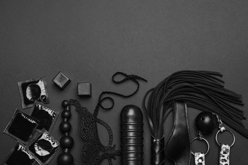 Different sex toys on black background, flat lay. Space for text