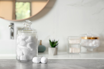 Cotton balls on light grey marble table in bathroom