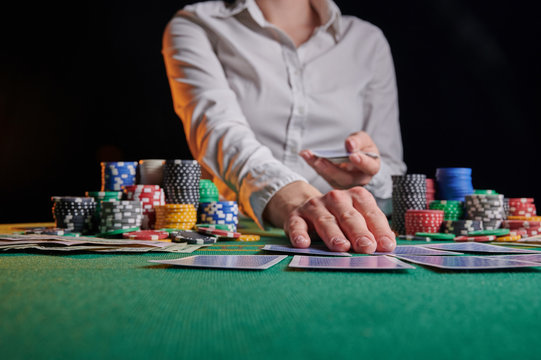 Croupier hands out cards on the background of casino chips
