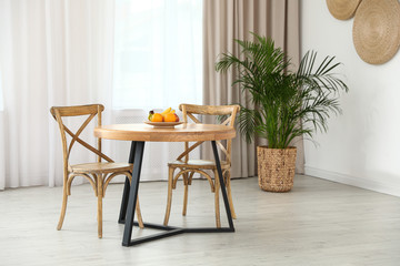 Stylish room interior with dining table and chairs