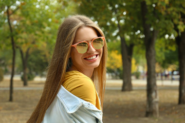 Young woman wearing stylish sunglasses in park