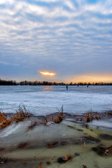 Vertical image of Frozen Lake at Sunset with Ice Fishermen
