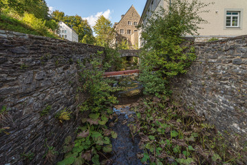 Bach mit  hoher Bruchsteinmauer