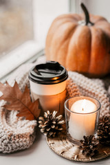 Obraz na płótnie Canvas Cup of coffee, pumpkin, dried autumn leaves on window. Autumn composition.