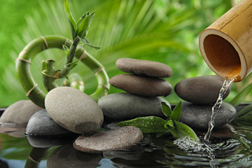 Composition with stones and bamboo fountain against blurred background. Zen concept