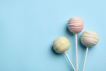 Sweet cake pops on light blue background, flat lay. Space for text