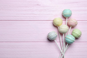 Sweet cake pops on pink wooden background, flat lay. Space for text