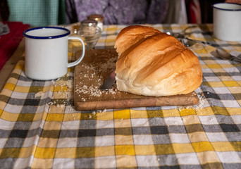 Old fashioned table set with meal with loaf of bread and range