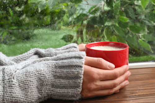 Woman With Cup Of Coffee Near Window On Rainy Day Closeup Wall Mural New Africa