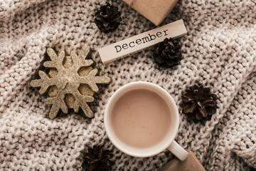 Fototapeta na wymiar Winter composition. Coffee cup, candle, nuts and on sweater background.