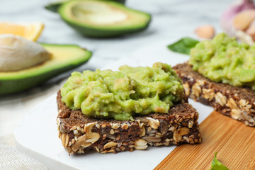 Tasty sandwiches with avocado spread on table, closeup