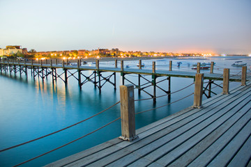 Obraz premium blue and red sky on the water over the pier