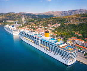Aerial view of cruise ship in harbor. Top view of beautiful large ships and boats at sunny day....