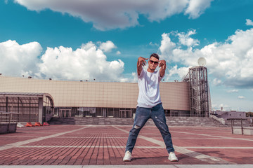 Fototapeta na wymiar Modern male dancer, breakdance dancing, in summer in city, free space for text, hip hop break dancer pose. Youth lifestyle, active, trendy, fitness sport, positive motivation.