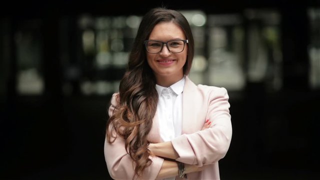 Young Beautiful Business Woman Or Student in Suit On the Street. She Is Smiling, Happy And Looking Into the Camera. Concept: New Business, Communication, Banker, Manager.