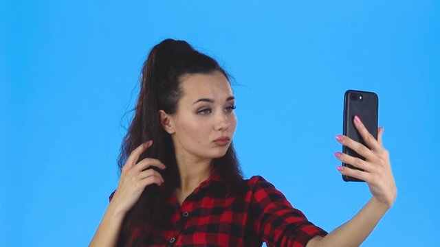Lady making selfie and with duckface on her phone. Slow motion