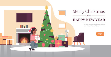 woman holding gift present box merry christmas happy new year holiday celebration concept girl in santa hat sitting near fir tree modern living room interior full length copy space horizontal vector