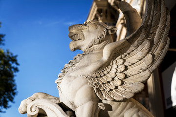 This image shows a griffin statue with a blue sky background.