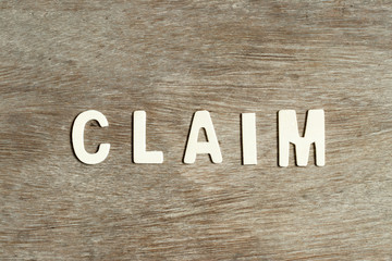 Alphabet letter in word claim on wood background