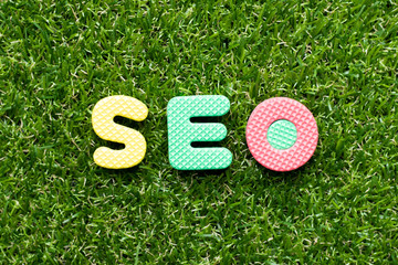 Toy foam letter in word SEO (Abbreviation of search engine optimization) on green grass background