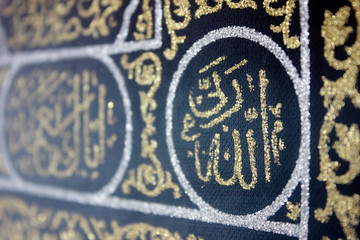 Fototapeta na wymiar close up golden arabic islamic calligraphy in black silk cloth kiswah cover of holy kaaba's door
