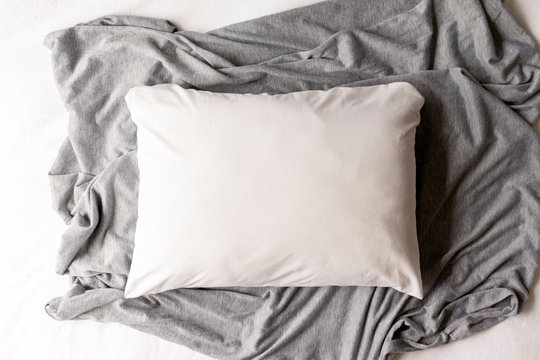 Plain white pillowcase on a grey and white textile background - cushion mockup - pillow flat lay