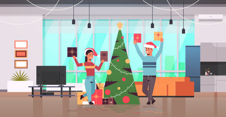 couple holding wrapped gift present boxes merry christmas happy new year holiday celebration concept man woman wearing santa hats modern living room interior flat full length horizontal vector