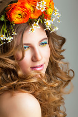 Naklejka premium Beauty young woman with flowers and make up close up, real spring beauty happy smiling
