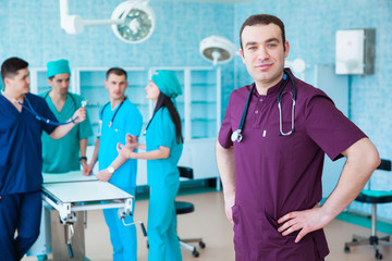 Obraz premium Portrait of a successful professional doctor. The staff of the medical faculty. multinational people - doctor, nurse and surgeon. A group of graduates of a medical university in a surgical room.