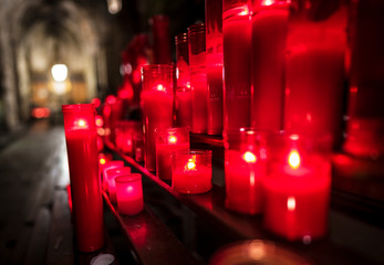 This image capture shows beautiful red, glowing prayer candles as they burn on an alter at night...